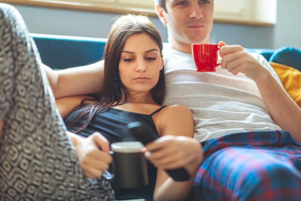 istock Couple watching TV together and drinking coffee 1205904990