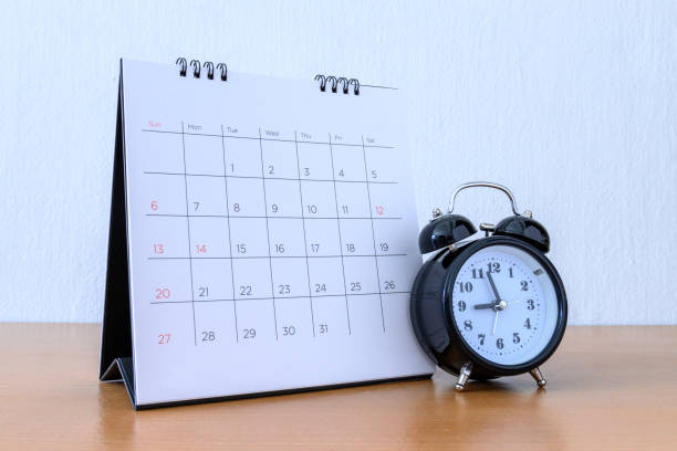 istock Calendar With Days and clock on wood table 1205905895