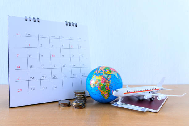 istock Airplane model with paper calendar on wooden table. plan for trip 1205905909