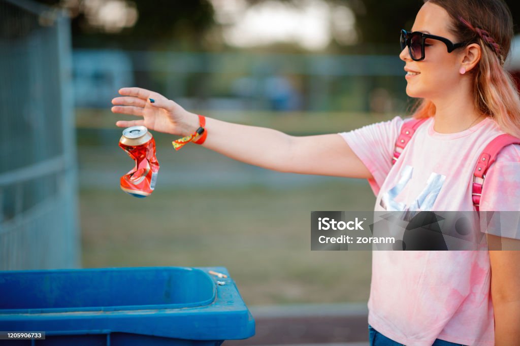 Recycling beer can Young woman recycling beer can at outdoor music festival Recycling Stock Photo