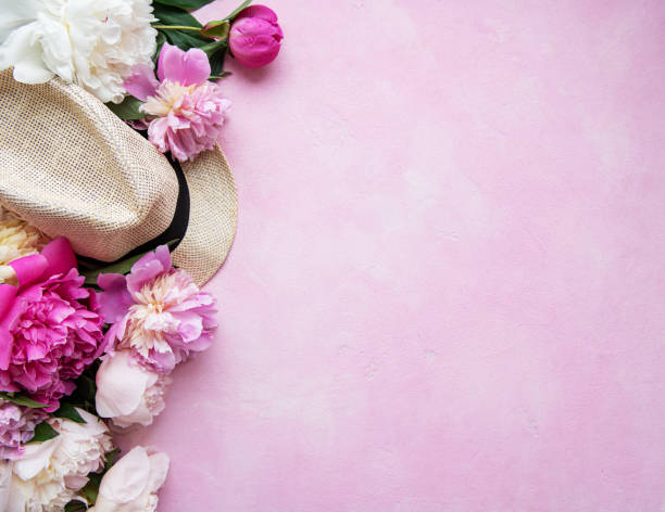istock Pink peonies and hat on a pink concrete background 1205910019