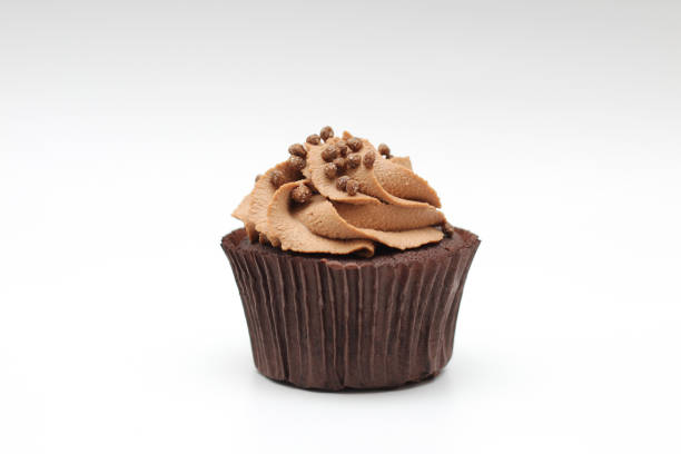 istock Isolated chocolate cupcake with cream top and crispy topping on a white background 1205911176