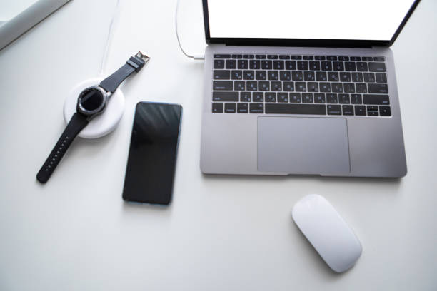 istock laptop with phone computer mouse and smart watch charging on wireless charger 1205912718