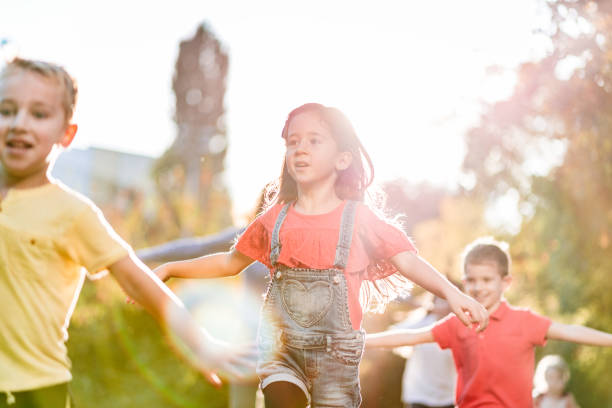 istock Happy kids running and playing in public park 1205913671