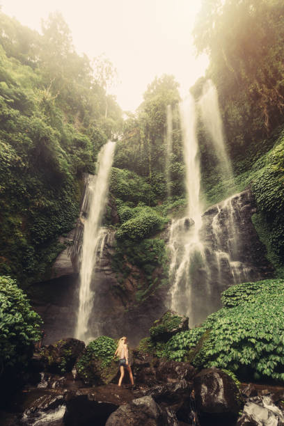 istock Young woman walking to jungle waterfall 1205913905