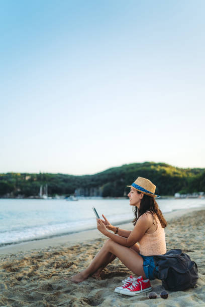 istock Woman at the beach using phone 1205914251