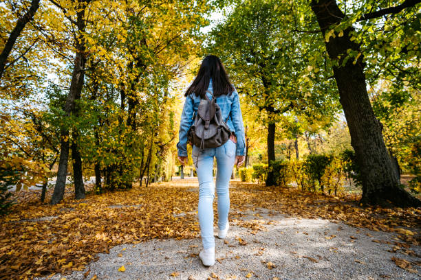 istock Woman walking in a park 1205915175