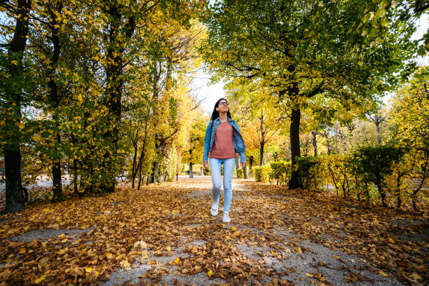 istock Woman walking in a park 1205915228