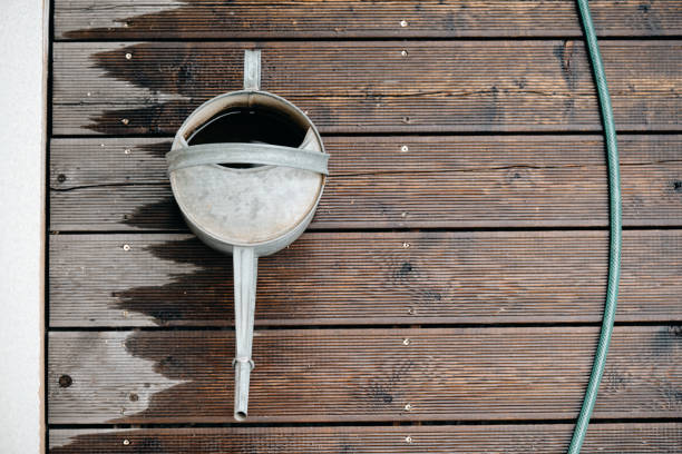 Old tube with blue oil paint on textured wooden table