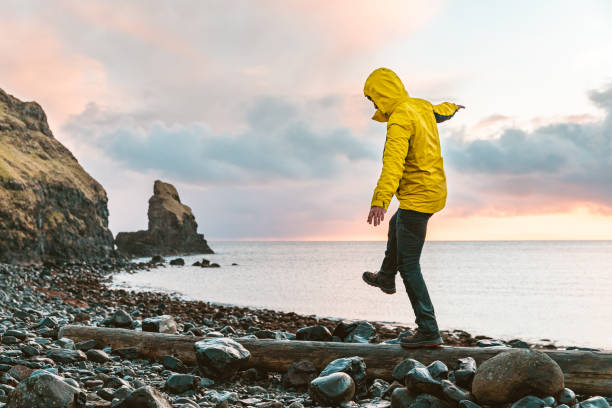 スコットランドの海辺で丸太の上にバランスにぶら下がっている男 - landscape scenics beach uk ストックフォトと画像