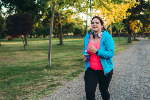 istock Young overweight woman running 1205917695