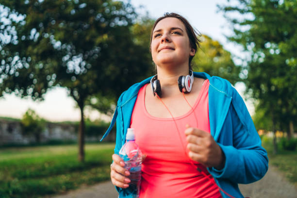 istock Young overweight woman running 1205917714