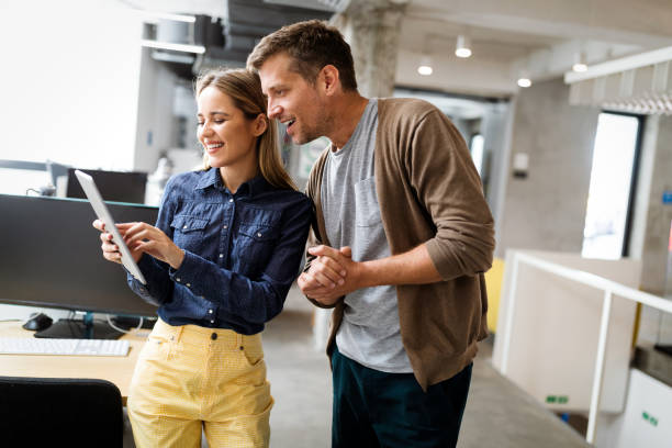 istock Colleagues discussing business and smiling while walking through the office corridor 1205921065