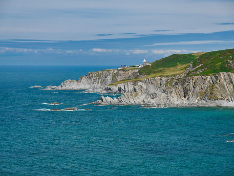The north Devon coast at Bull Point, showing the Lighthouse and outbuildings. The steeply inclined slate strata of the Morte Slates Formation is visible in the foreground.