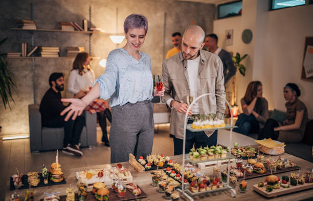 istock Young business colleagues sampling savory dishes at corporate office party 1205928696