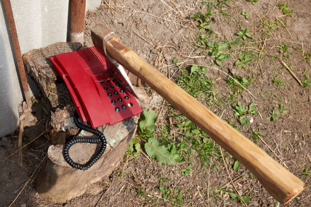 A large ax sticks out in an outdated push-button telephone.
