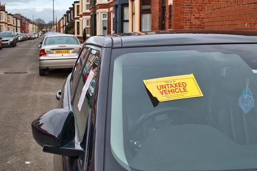 A notice is displayed on an untaxed vehicle advising that a report has been passed to the DVLA for enforcement action