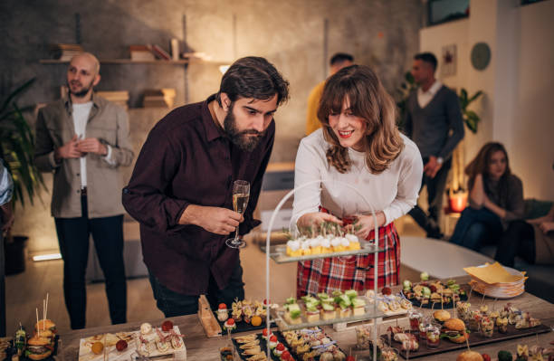 istock Young business colleagues sampling savory dishes at corporate office party 1205934163