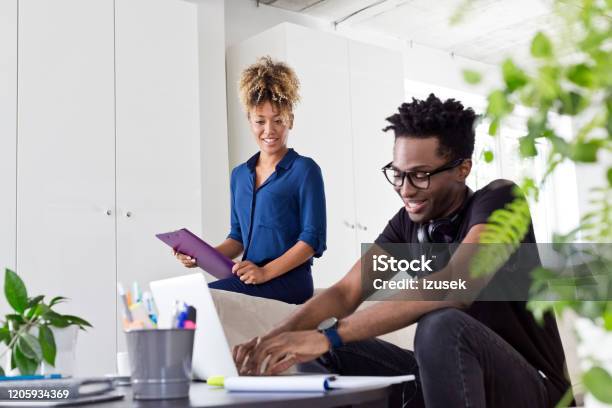 Smiling Professionals Working At Creative Office Stock Photo - Download Image Now - 30-34 Years, Adult, Adults Only