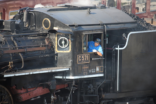 Japanese man opperating a stem train in Tokyo, Japan