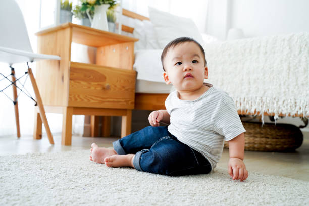 istock Asian boy sitting on the floor alone at home next to bed 1205936476