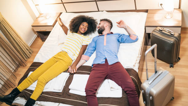 istock Couple in love lying down on bed in hotel room 1205937365