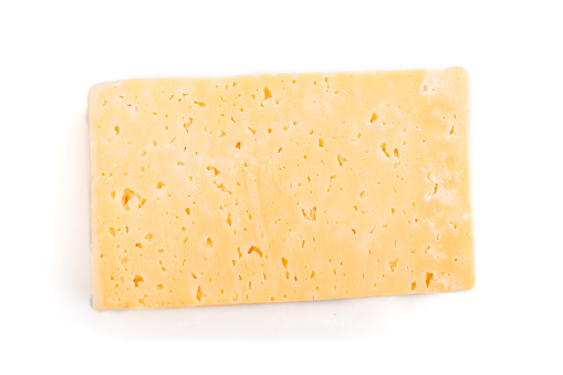 Piece of yellow cheese isolated on white background. Top view, close up.