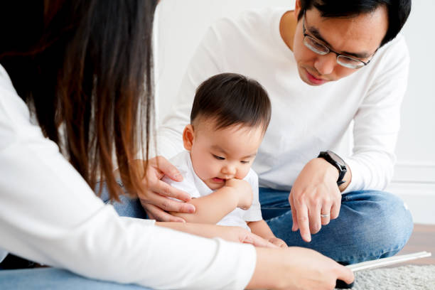 istock Young parents reading book for little son 1205942152