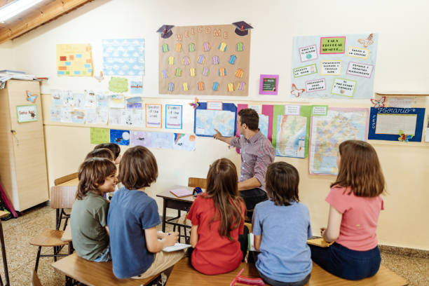 istock Latino teacher with Hispanic kids in classroom at school 1205944304
