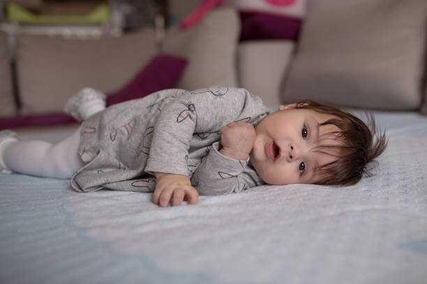 istock Baby girl lying down on a bed 1205945117