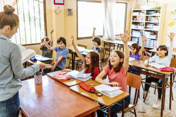 istock Female Latina teacher in classroom with elementary school pupils 1205946046