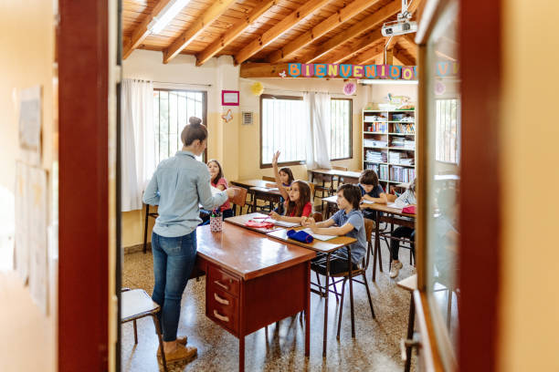 istock Female Latina teacher in classroom with elementary school pupils 1205947095