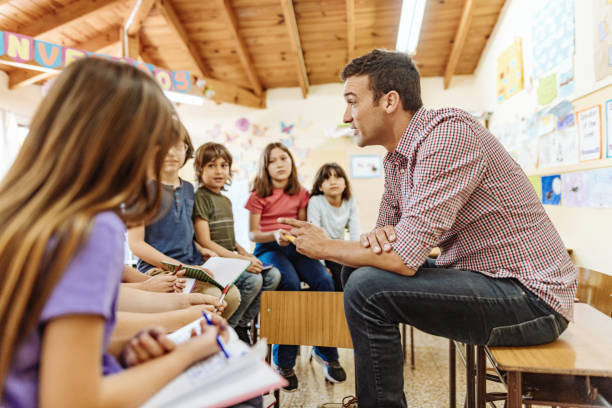 istock Latino teacher with Hispanic kids in classroom at school 1205947171