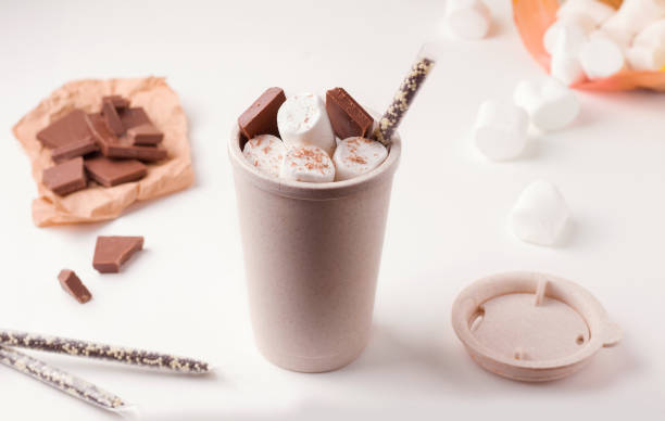 istock reusable coffee cup with marshmallows and chocolate on a white plate next to the ingredients 1205947607