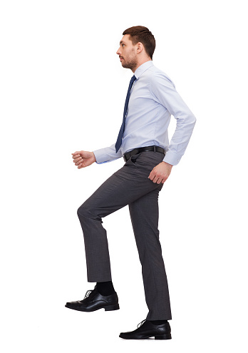 business and education concept - serious businessman stepping on imaginary step