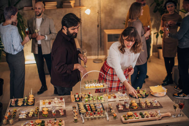 istock Business colleagues sampling savory dishes at corporate office party 1205948959