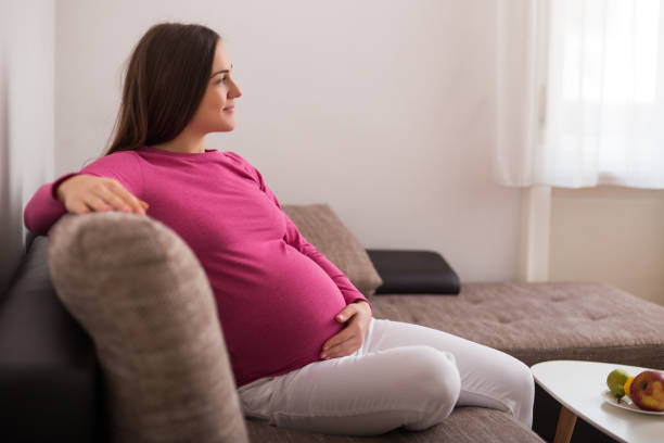 istock Pregnant woman sitting on sofa 1205951533