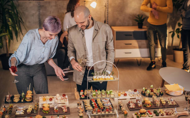 istock Business colleagues sampling savory dishes at corporate office party 1205954248