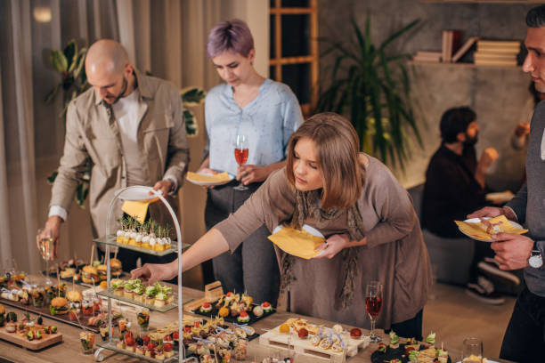 istock Business colleagues sampling savory dishes at corporate office party 1205954306