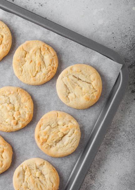 istock White chocolate biscuit cookies on baking tray on light kitchen table background. 1205955045
