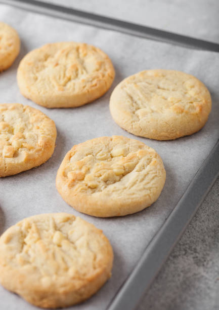 istock White chocolate biscuit cookies on baking tray on light kitchen table background. 1205956687