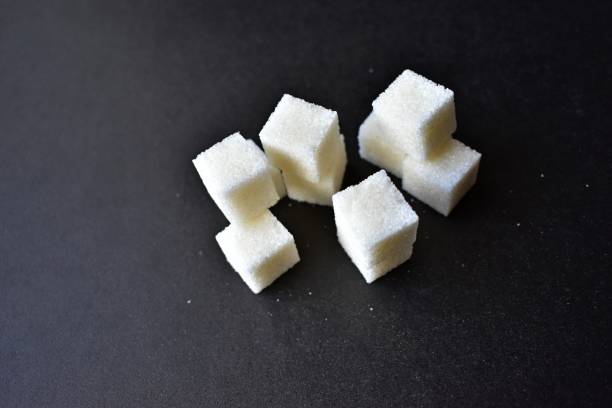 istock Square pieces of refined sugar on a black background 1205956833