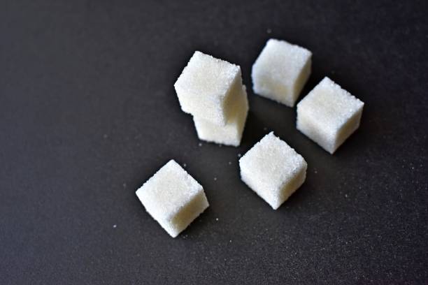 istock Square pieces of refined sugar on a black background 1205956836