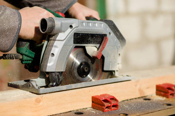 istock Cutting a standing worker and sawing with a circular saw, industrial construction connecting wooden beams 1205956922
