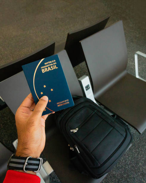 sosteniendo un pasaporte brasileño, mochila sobre el fondo. concepto de viaje - editorial use audio fotografías e imágenes de stock