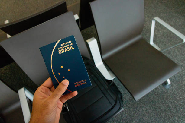 Holding a brazilian passport, backpack on background.Travel concept