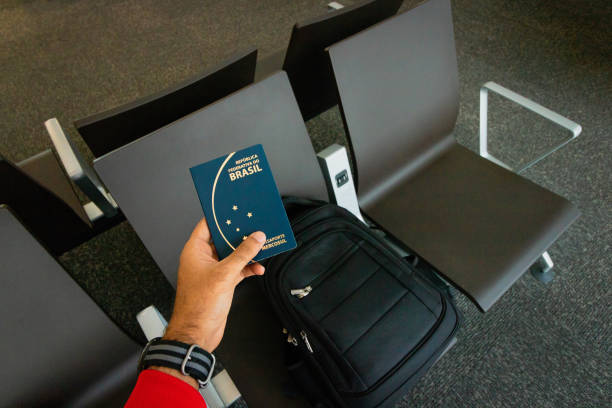 istock Holding a brazilian passport, backpack on background.Travel concept 1205960349