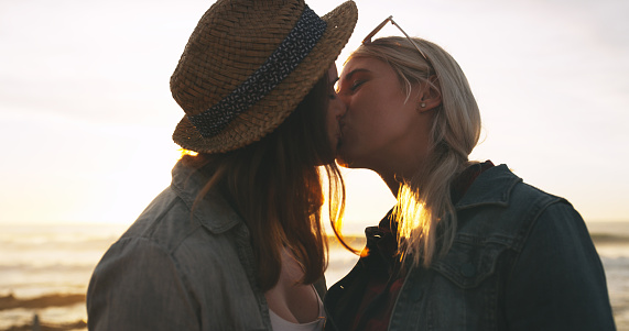 Shot of an affectionate and happy young couple kissing while spending the day together outdoors near the beach