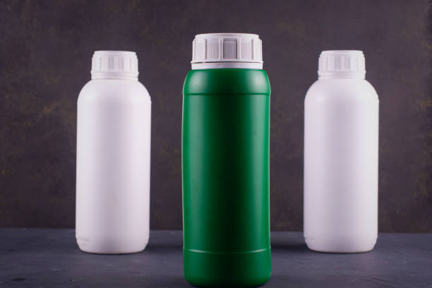 istock Three plastic pesticide bottles on a dark background. 1205962455