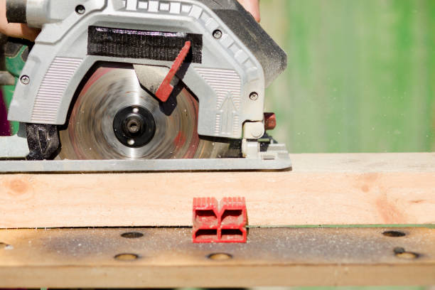 istock Cutting a standing worker and sawing with a circular saw, industrial construction connecting wooden beams 1205962525